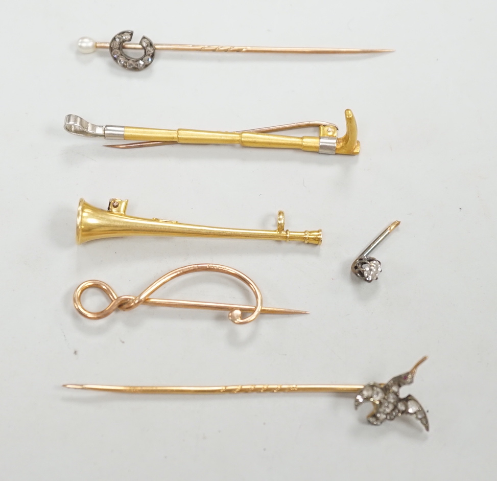 An Edwardian 15ct riding crop brooch(a.f.), 59mm, 2.8 grams, an 18ct hunting horn brooch (lacking pin) 2.1 grams, two Victorian diamond cluster set stick pins including swan in flight, a diamond set pin terminal, gross 4